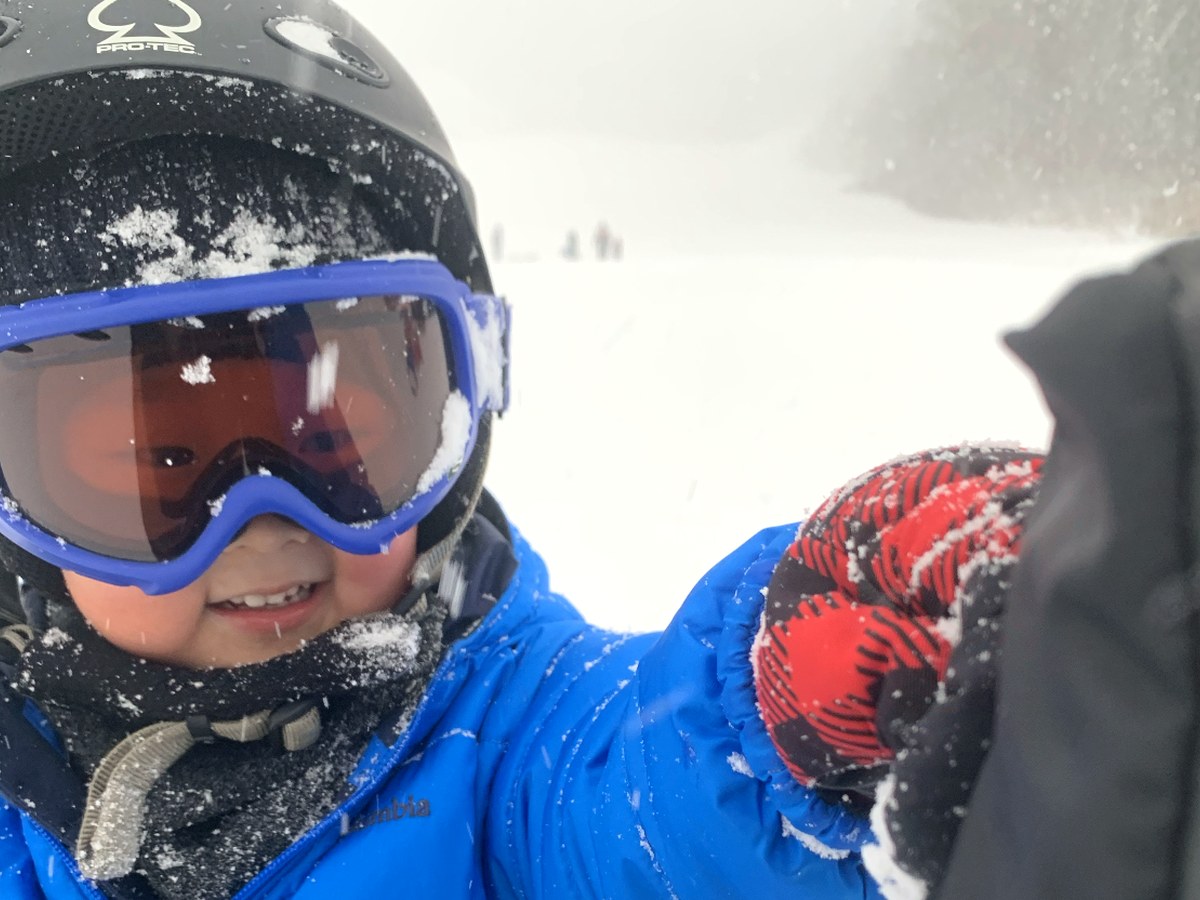 雪の中で笑顔を見せる子ども