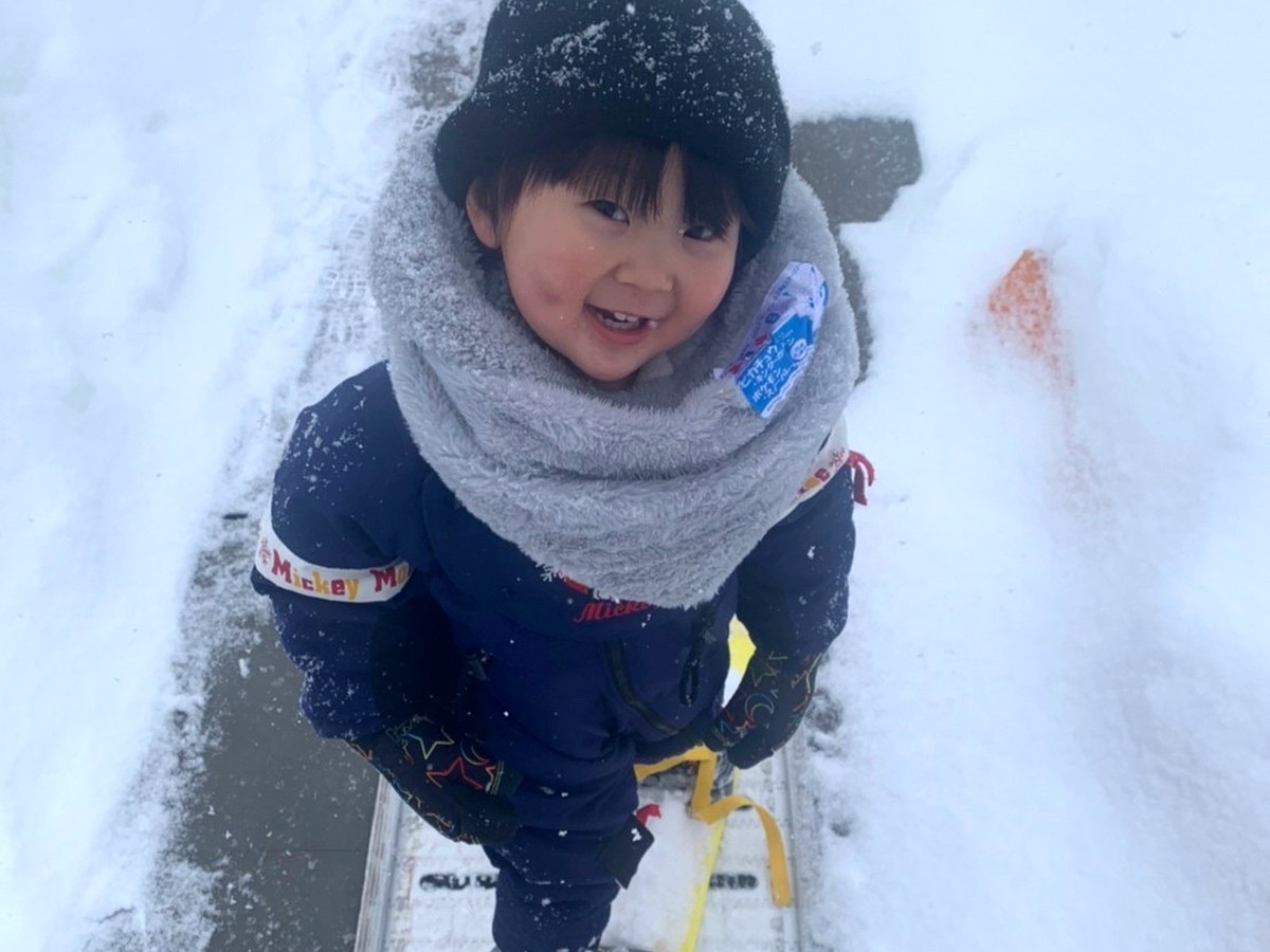 雪の中で楽しそうに笑う子ども