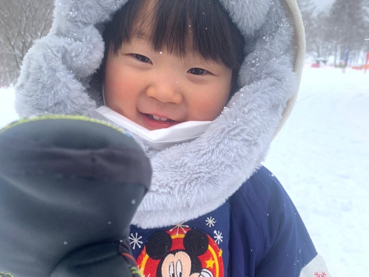 雪の中で笑顔を見せる子ども