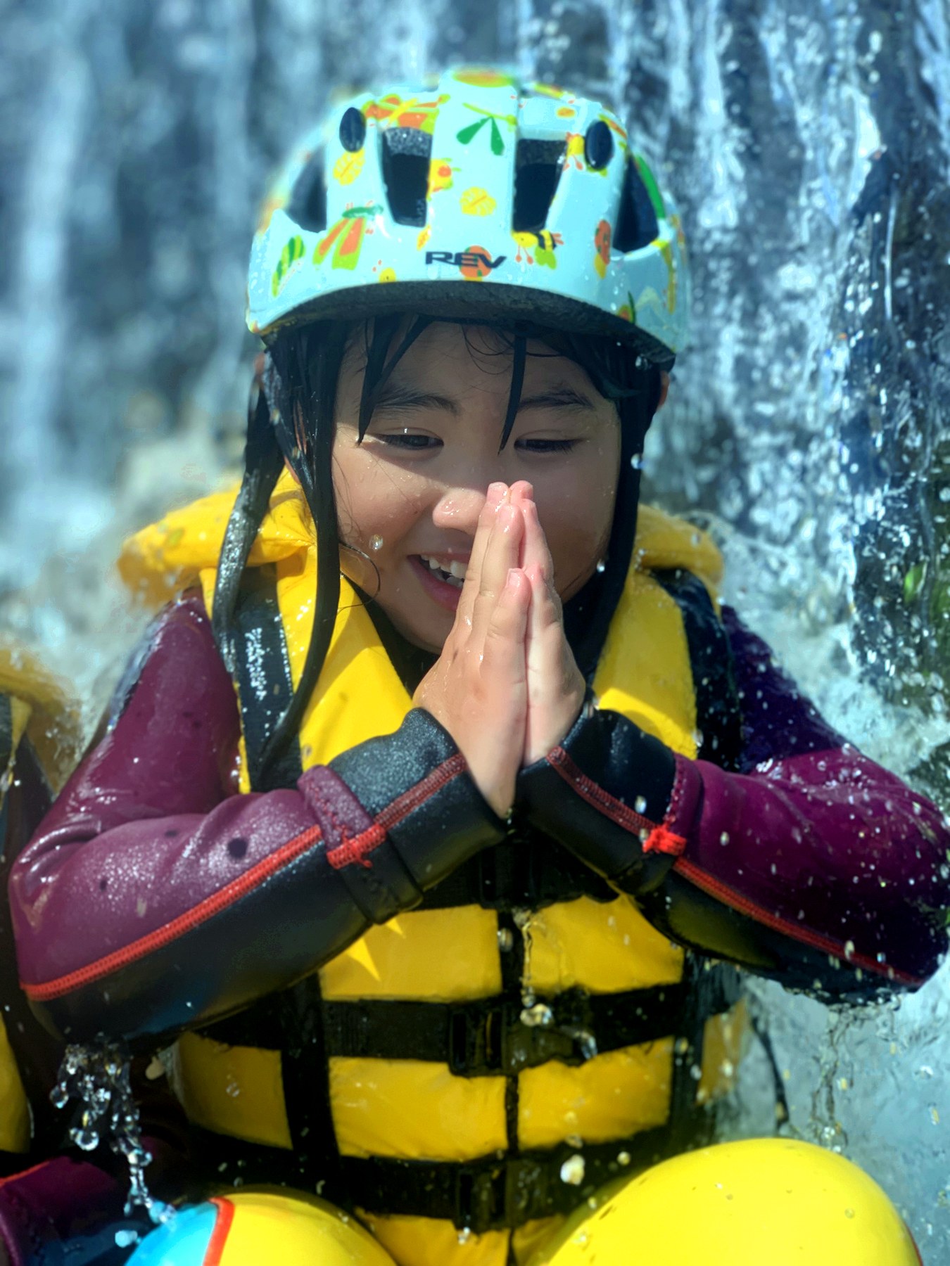 滝のそばで水遊びを楽しむ子ども