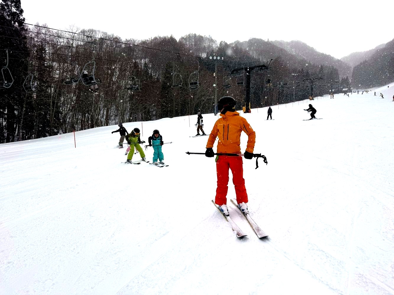 雪のゲレンデで子どもたちを見守るスキーレッスン