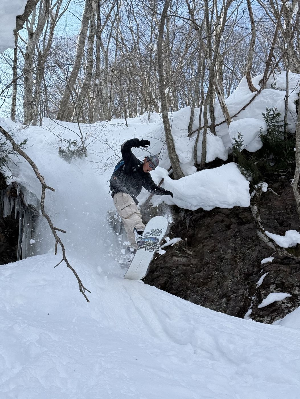 バックカントリーで雪を上げるスノーボード上達レッスン