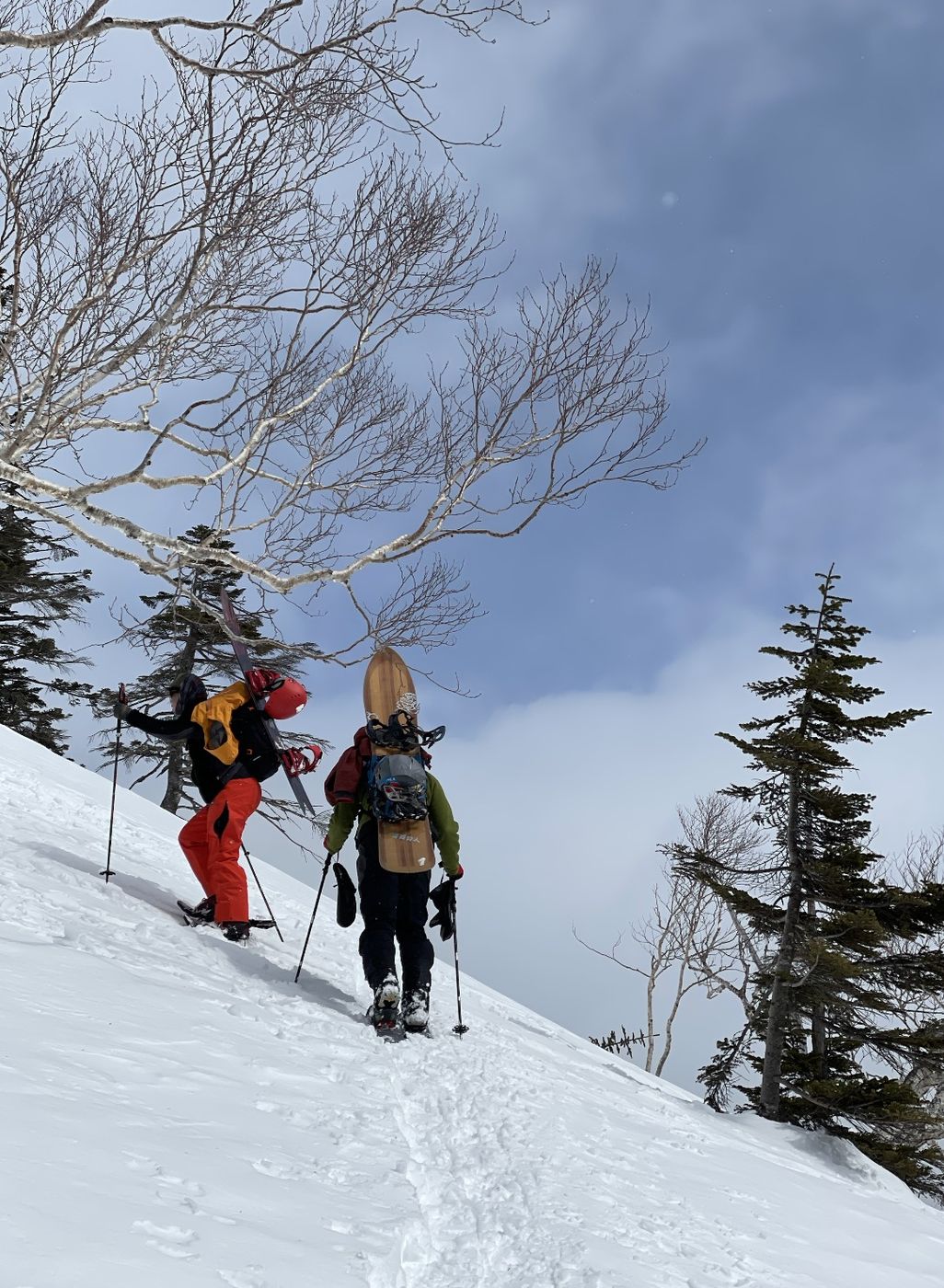 雪山を登るスノーボーダー