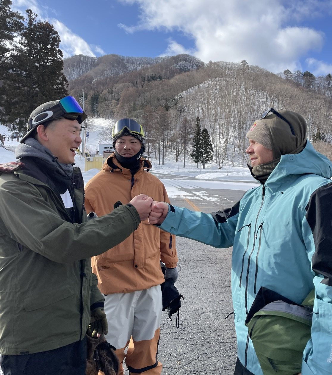 雪山で仲間と笑うスノーボーダー