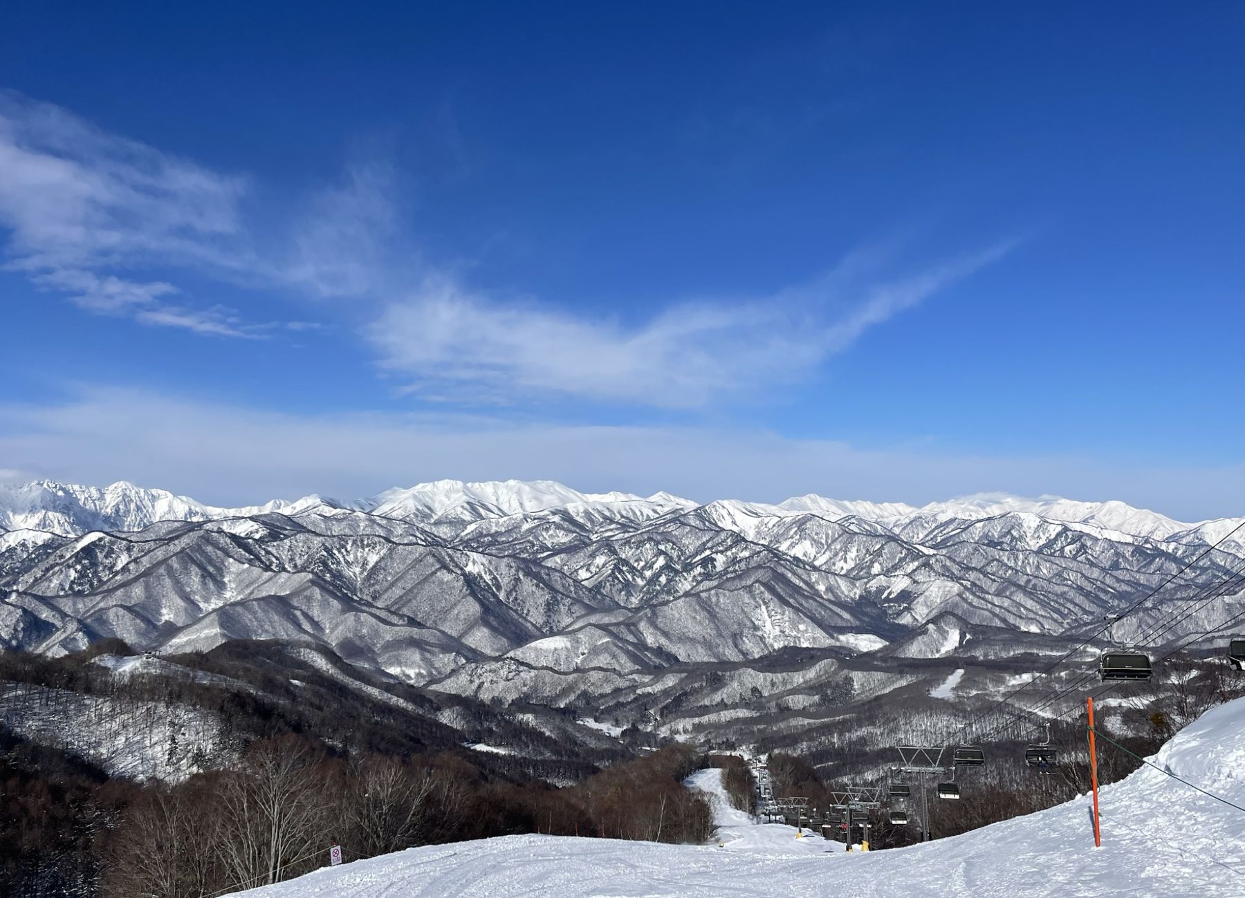 青空と雪山が広がる冬のゲレンデ